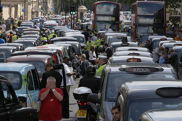 Taxi drivers block the road in Whitehall in central London June 11, 2014. While taxi drivers go on strike, Uber has seen an 850 percent increase in sign-ups for the app. Luke MacGregor/Reuters