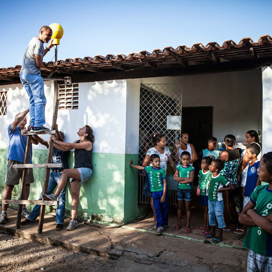 Project Loon team members setting up an antenna on the rooftop of a Brazillian School