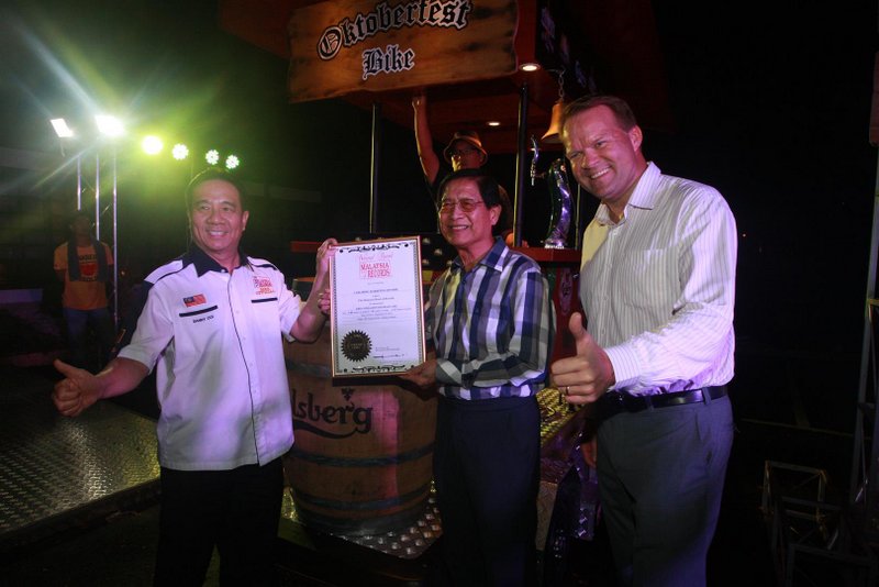 YBhg Tan Sri Danny Ooi [left], Founder of the Malaysia Book of Records, presented Carlsberg Malaysia's Chairman of the Board Dato' Lim Say Chong [middle] and Managing Director Henrik Juel Andersen [right] with the award for Malaysia's "First 6 Pedalist Beverage 