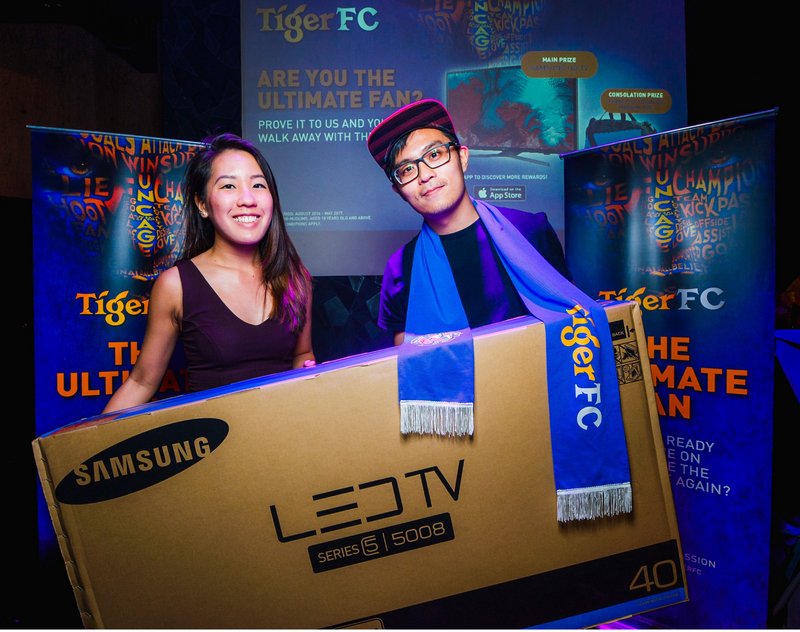 Ashley Choo, Brand Executive of Tiger beer (left) presenting the grand prize to Ng Chee Wee (right) during Tiger FC viewing party at Gridiron, Bangsar